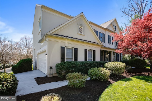 view of property exterior featuring stucco siding, concrete driveway, and a garage