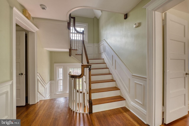 2305 Macdonough Rd, Wilmington, DE 19805 - stairs featuring a decorative wall, wainscoting, wood finished floors, and arched walkways