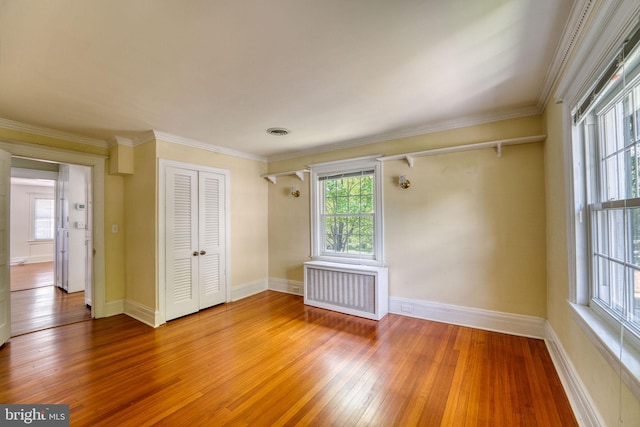 2305 Macdonough Rd, Wilmington, DE 19805 - spare room featuring radiator heating unit, light wood-style floors, baseboards, and crown molding