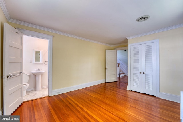 2305 Macdonough Rd, Wilmington, DE 19805 - unfurnished bedroom with ornamental molding, light wood finished floors, baseboards, a closet, and ensuite bathroom