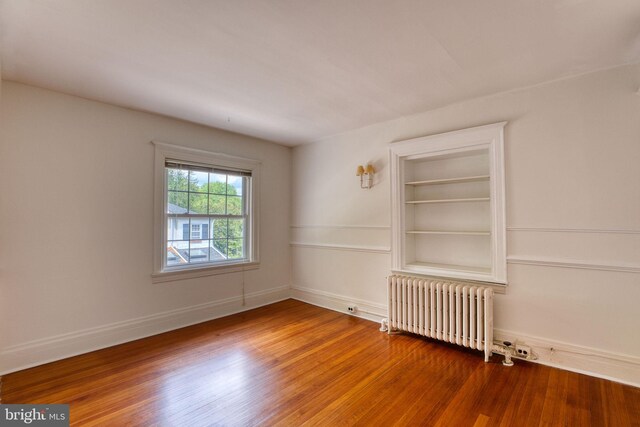 2305 Macdonough Rd, Wilmington, DE 19805 - empty room with radiator, wood finished floors, and baseboards