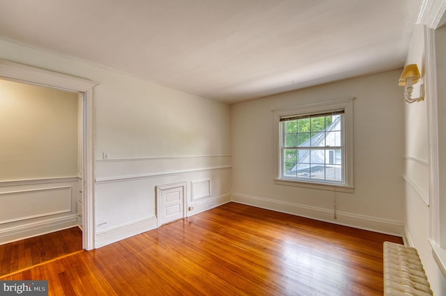 2305 Macdonough Rd, Wilmington, DE 19805 - empty room featuring wood finished floors, wainscoting, and radiator heating unit
