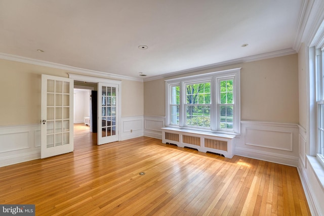 2305 Macdonough Rd, Wilmington, DE 19805 - unfurnished room with radiator, french doors, light wood finished floors, wainscoting, and crown molding