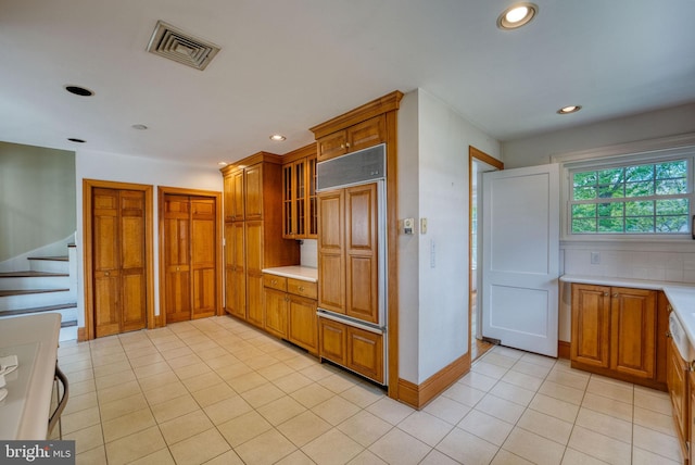 2305 Macdonough Rd, Wilmington, DE 19805 - kitchen featuring paneled built in fridge, brown cabinetry, light countertops, light tile patterned floors, and recessed lighting