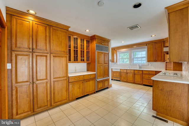 2305 Macdonough Rd, Wilmington, DE 19805 - kitchen featuring paneled appliances, brown cabinetry, decorative backsplash, light countertops, and glass insert cabinets