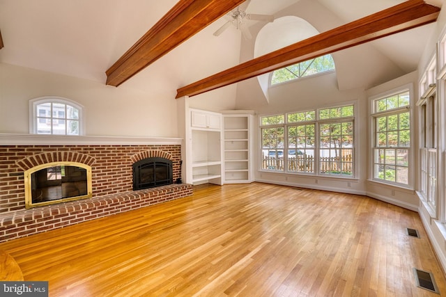 2305 Macdonough Rd, Wilmington, DE 19805 - unfurnished living room with light wood-style floors, high vaulted ceiling, a fireplace, beamed ceiling, and a ceiling fan