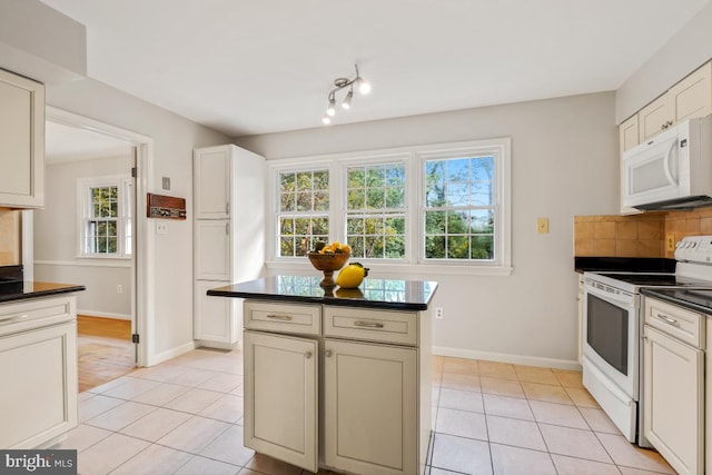 kitchen with white appliances, dark countertops, light tile patterned floors, baseboards, and backsplash