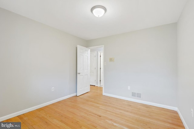 unfurnished room featuring baseboards and light wood finished floors