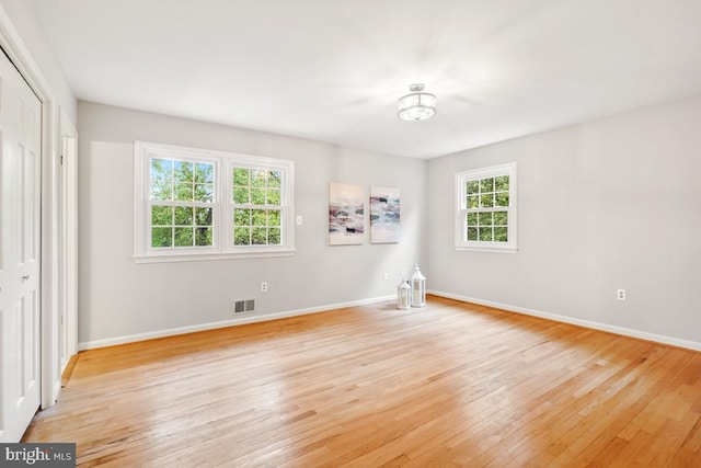 unfurnished bedroom with light wood-style flooring, baseboards, and a closet
