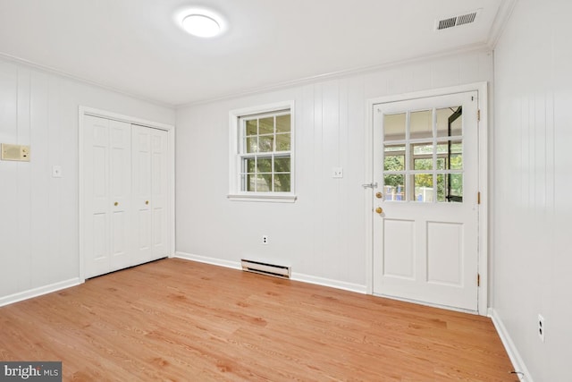 doorway to outside with baseboard heating, crown molding, light wood-style floors, and baseboards