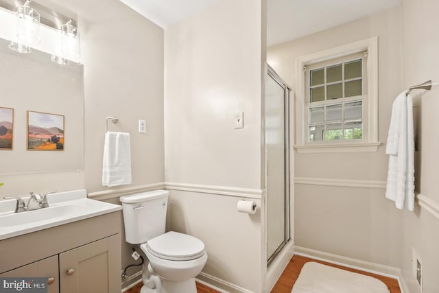 full bathroom featuring vanity, a stall shower, toilet, and wood finished floors