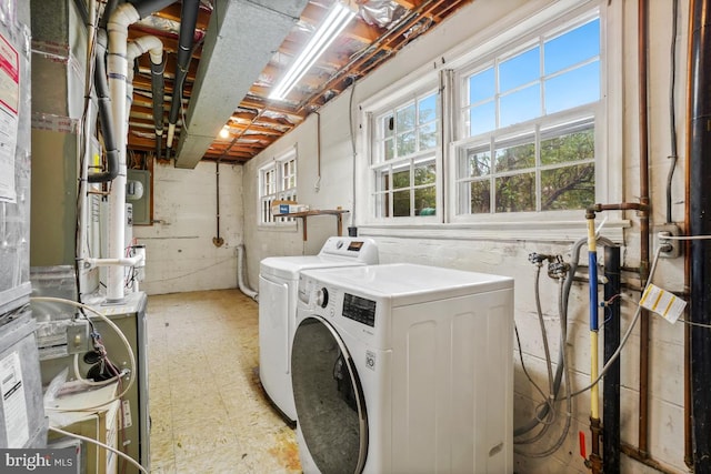clothes washing area with washing machine and dryer and tile patterned floors