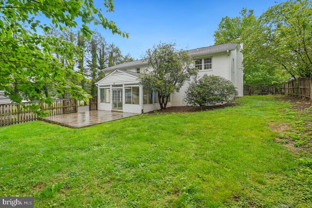 rear view of house featuring a sunroom and a patio