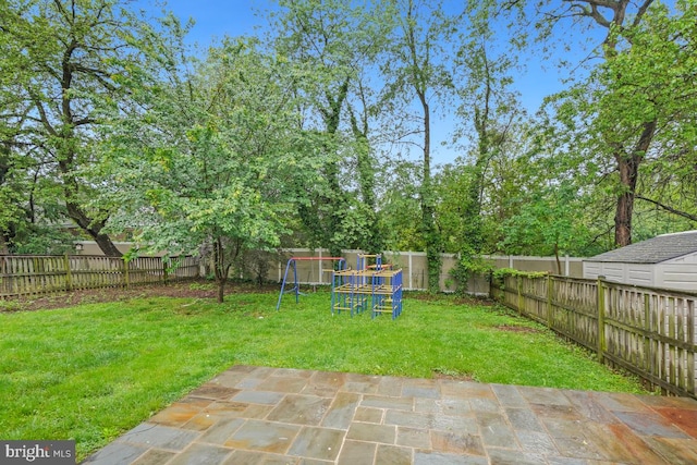 view of yard featuring a playground and a patio area