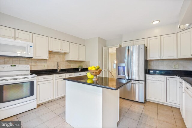 kitchen with white appliances, light tile patterned floors, tasteful backsplash, white cabinets, and recessed lighting