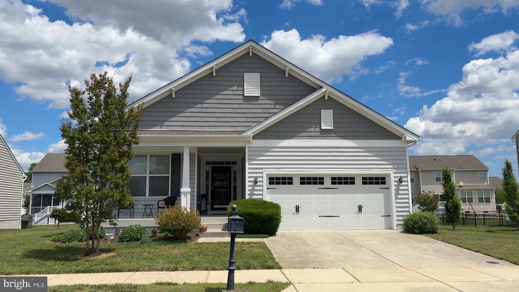 view of front facade with covered porch, a front lawn, a garage, and driveway