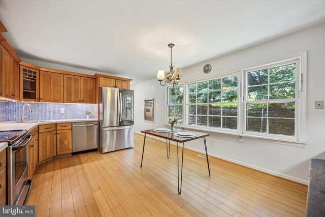 343 Michigan Ave, Swarthmore, PA 19081 - kitchen featuring stainless steel appliances, brown cabinets, a chandelier, tasteful backsplash, and light countertops