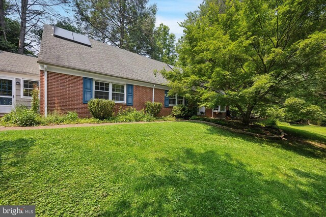343 Michigan Ave, Swarthmore, PA 19081 - view of front of property featuring brick siding, a front yard, and roof with shingles