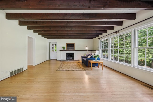 343 Michigan Ave, Swarthmore, PA 19081 - living area featuring light wood finished floors, beam ceiling, and a fireplace with raised hearth