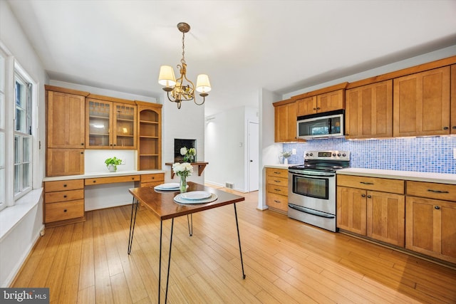 343 Michigan Ave, Swarthmore, PA 19081 - kitchen featuring stainless steel appliances, brown cabinetry, light countertops, decorative backsplash, and decorative light fixtures