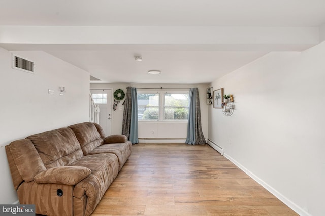 living room featuring a baseboard radiator, light wood finished floors, and baseboards