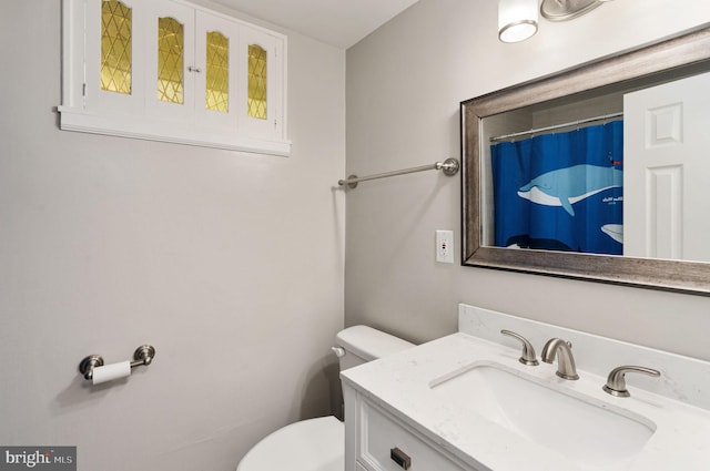 bathroom featuring toilet, vanity, and a shower with shower curtain