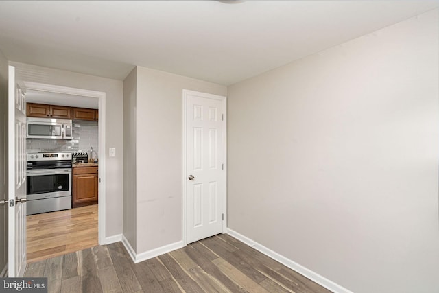unfurnished room featuring wood finished floors and baseboards