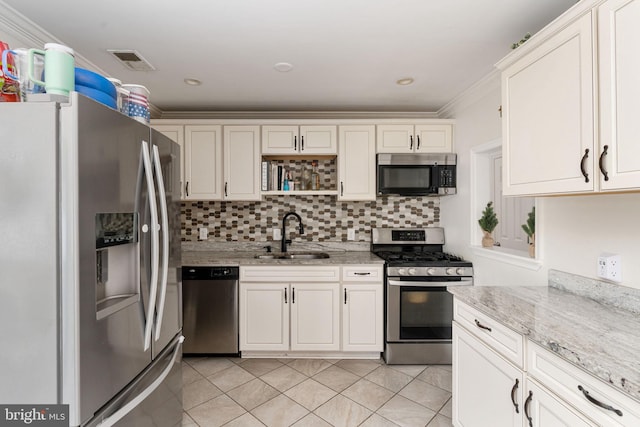 kitchen featuring appliances with stainless steel finishes, a sink, backsplash, light tile patterned floors, and open shelves