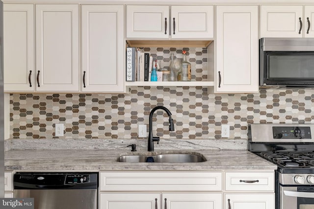 kitchen with stainless steel appliances, a sink, light countertops, and backsplash