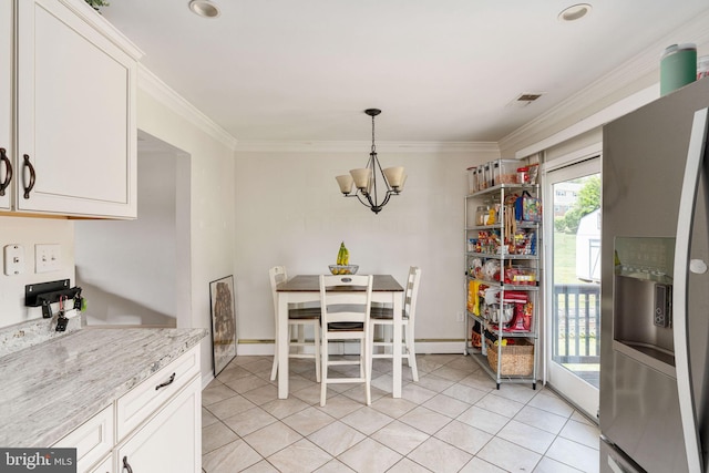 dining room featuring crown molding, a chandelier, light tile patterned floors, and baseboards