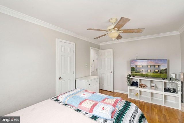 bedroom with ornamental molding, wood finished floors, baseboards, and a ceiling fan