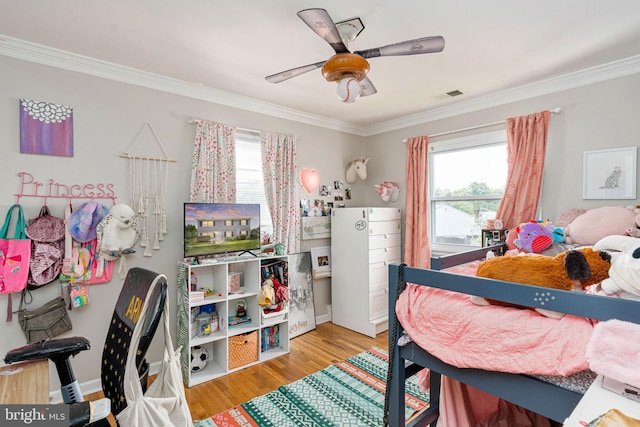 bedroom with crown molding, multiple windows, wood finished floors, and a ceiling fan