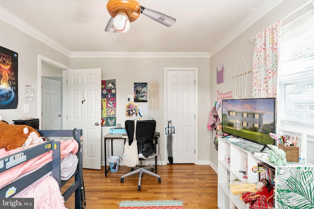 bedroom featuring wood finished floors, crown molding, a desk, and a ceiling fan