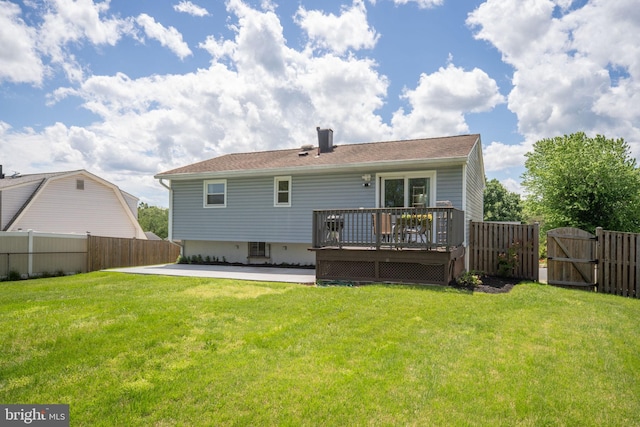 rear view of property with a deck, a gate, and a chimney