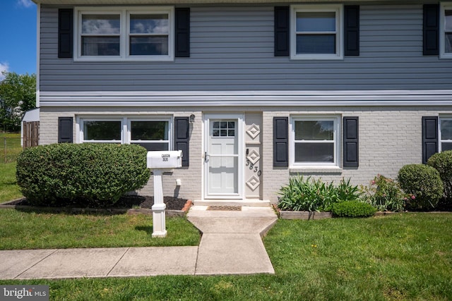 view of front of home featuring a front yard and brick siding