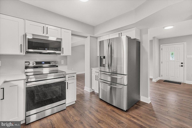 6121 Ducketts Ln, Elkridge, MD 21075 - kitchen featuring stainless steel appliances, light countertops, white cabinets, and dark wood finished floors