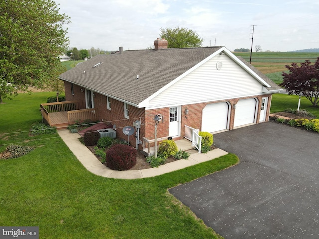 view of front of house featuring brick siding, a chimney, a garage, and asphalt driveway