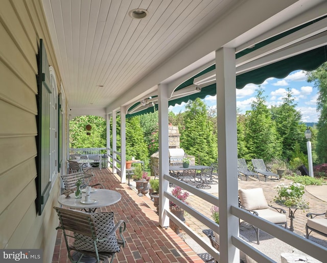 view of patio featuring outdoor dining area and a porch