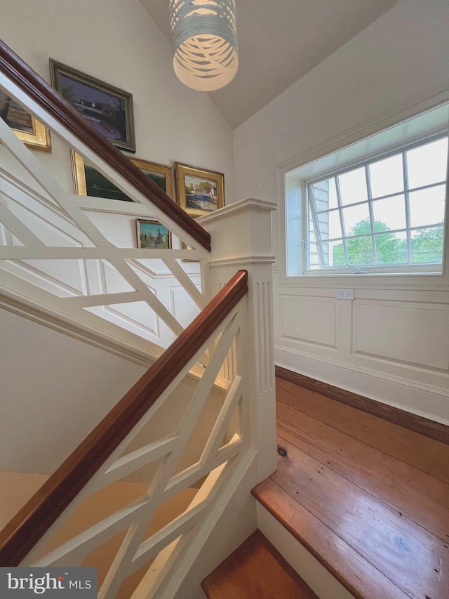 stairway featuring lofted ceiling and wood finished floors