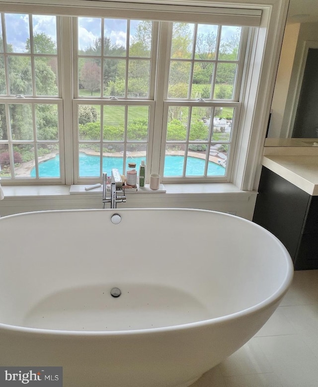 bathroom with a soaking tub and tile patterned flooring