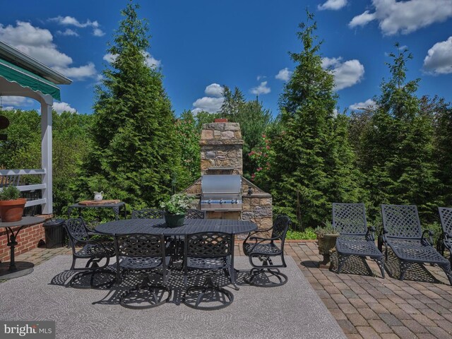 view of patio / terrace featuring an outdoor fireplace and outdoor dining space