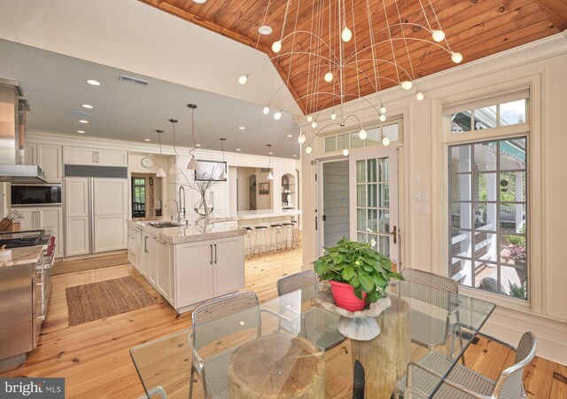 dining room with lofted ceiling, wood ceiling, light wood finished floors, ornamental molding, and recessed lighting