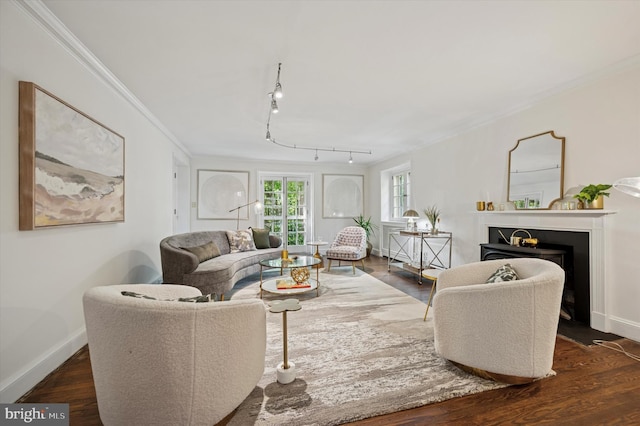 living room with ornamental molding, dark wood finished floors, a fireplace with flush hearth, and baseboards