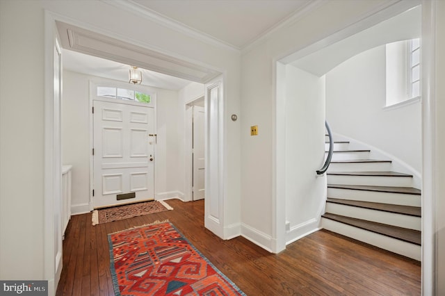 foyer with dark wood-style flooring, baseboards, crown molding, and stairs