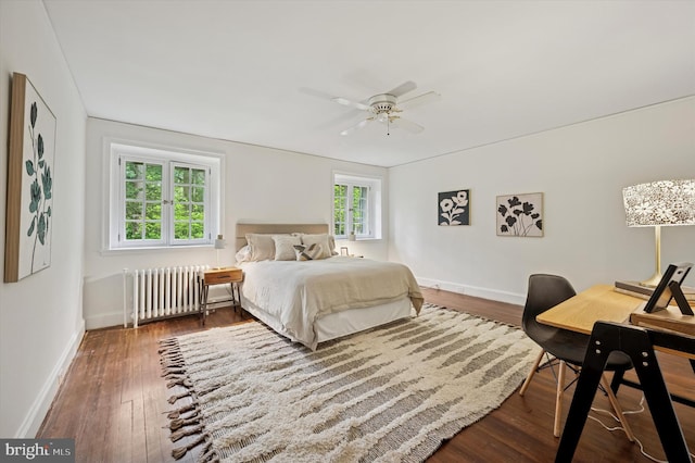 bedroom featuring radiator, baseboards, wood finished floors, and ceiling fan