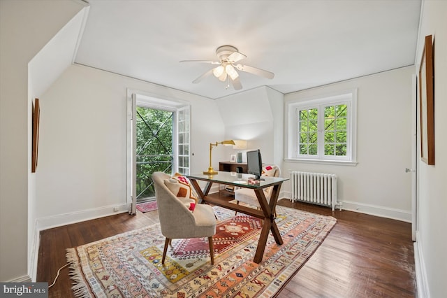 office space with radiator heating unit, a ceiling fan, wood finished floors, and baseboards