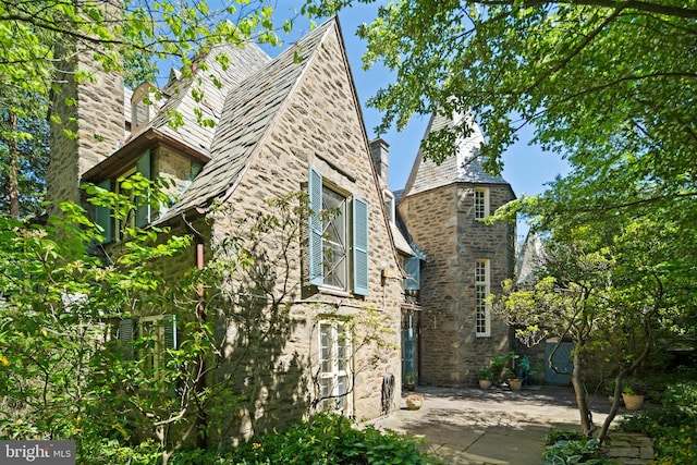 view of home's exterior with a patio and stone siding