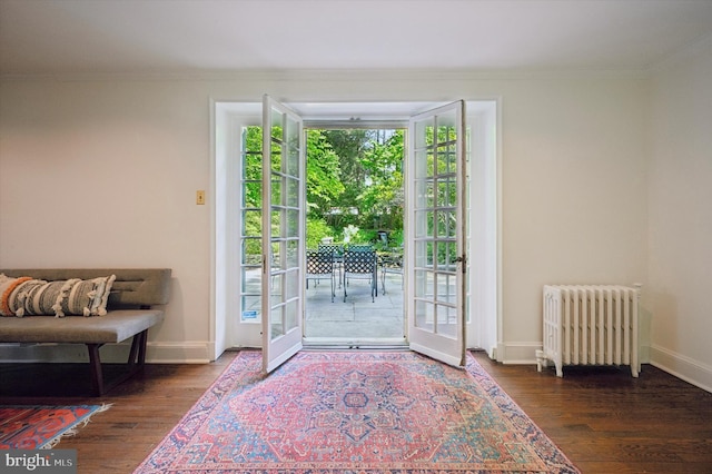 doorway with radiator, ornamental molding, wood finished floors, baseboards, and french doors