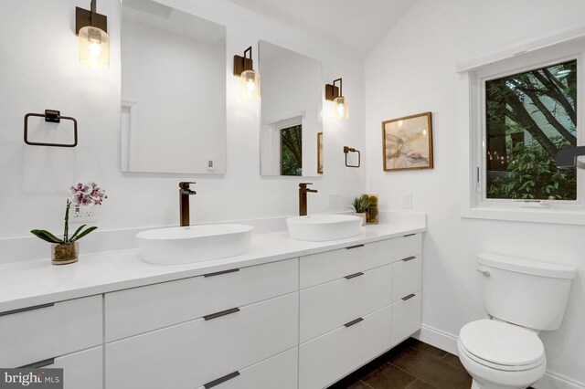 5018 36th St N, Arlington, VA 22207 - bathroom with double vanity, toilet, baseboards, tile patterned floors, and lofted ceiling