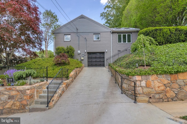 5018 36th St N, Arlington, VA 22207 - view of home's exterior with concrete driveway, a garage, stairs, and brick siding